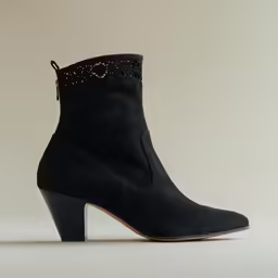 a pair of black sued ankle high boots with embellishments and platform