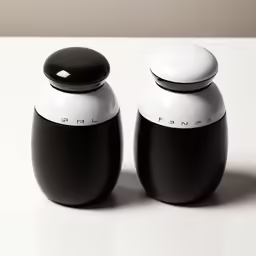 two empty black and white containers sit on a white table