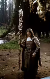 a person is standing in the woods with a staff