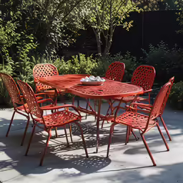 an empty red table and chairs set in the middle of a patio