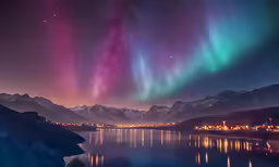 the aurora display lights above a mountain lake and town