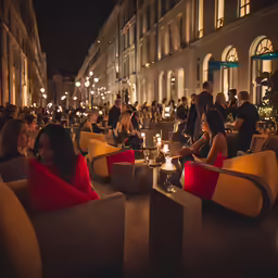 many people are sitting and drinking at a table outside