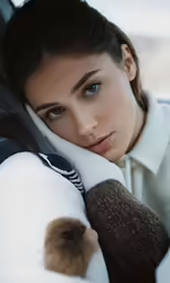 a woman is leaning her head on the arm of a car