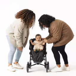 a woman is holding the hand of a small child as another child in a stroller looks on