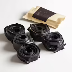 a group of four black and silver cameras