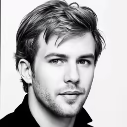 the head and shoulders of a man in a shirt looking to his left