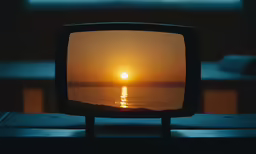 the reflection of an orange sunset in a small, black mirror