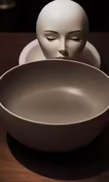 a statue sitting behind a bowl on top of a table