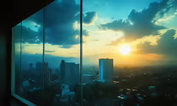 a sunset with the reflection of clouds and buildings in a window