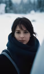 there is a woman standing in the snow, with her hand on her shoulder