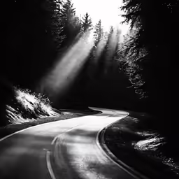 a light shines on the road in a black and white image