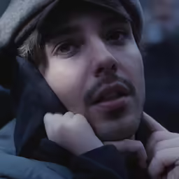a man with a cap on standing outside