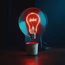 an illuminated light bulb over a small cup