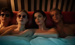 three people and one is laying in bed