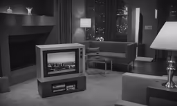 black and white photograph of living room area with a tv