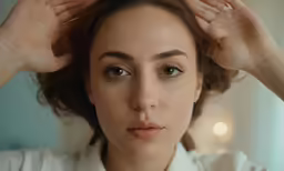 a woman holding her hair in the wind