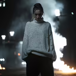 woman in dark outfit wearing knit sweater and neck warmer
