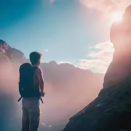 a person with a backpack standing on the edge of a cliff