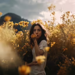 young woman standing in flowery field blowing smoke