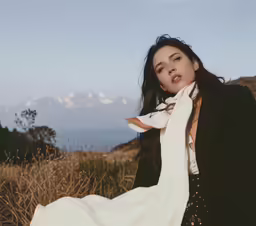 a woman with an unkempt neck is sitting in a field