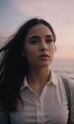 the woman is standing on the beach by the water