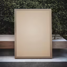 a white sheet on a concrete surface next to a bush