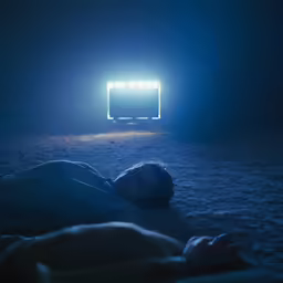 the image is taken from the side of a man laying in a room with a light up