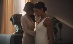 two woman standing together in a room