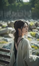 a woman with long hair sitting by the water