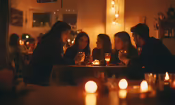 four people are sitting around a table at night