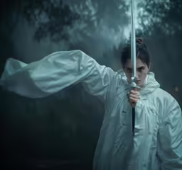 a woman holding a giant white knife in her hand