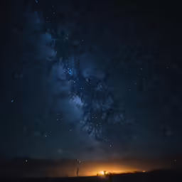 stars, the lights of a tent and a car are glowing in the dark