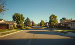 a street with houses, cars, and parked vehicles