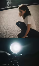 a woman sitting on a road with a camera