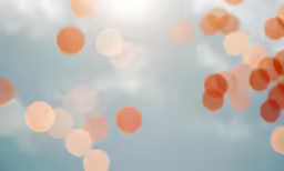 a blue and white sky with orange and white circles floating