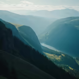 a valley that has green hillside and trees on the side