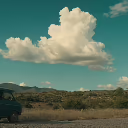 the car is driving on the gravel road