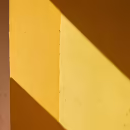 an orange and yellow wall with small white shadows