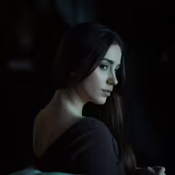 a woman is sitting and staring into the distance