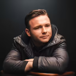 the young man is posing in front of a table
