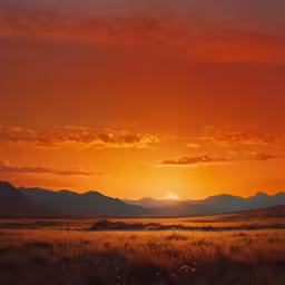a photo of a sun setting over some mountains