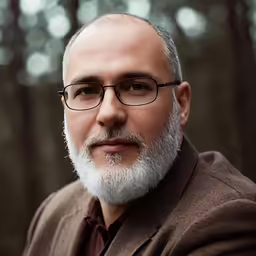 an image of a man in glasses looking at the camera