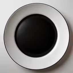 black and white plate on grey table with white background