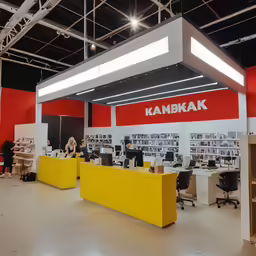 a large room with two computers and people