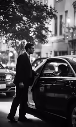 the man is walking toward the car parked in front of him