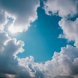 sun rays peek through the clouds of a cloudy sky