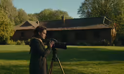 a woman filming something outside with a camera