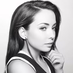 a woman wearing black and white poses for the camera