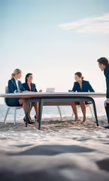 four women sitting at a table on the beach