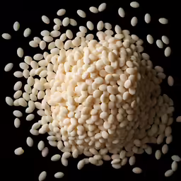 a bunch of beans sitting on top of a black surface